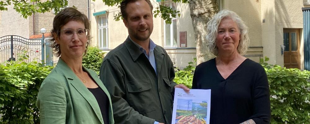 Rasmus Törnblom tar emot klimatpolitiska rådets rapport 2026 av rådets vice ordförande Åsa Knaggård (till vänster) och ordförande Misse Wester (till höger). Foto: Lunds kommun